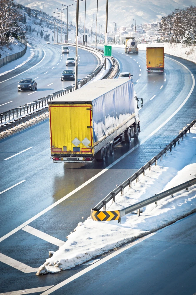 Camiones circulando por una autopista nevada